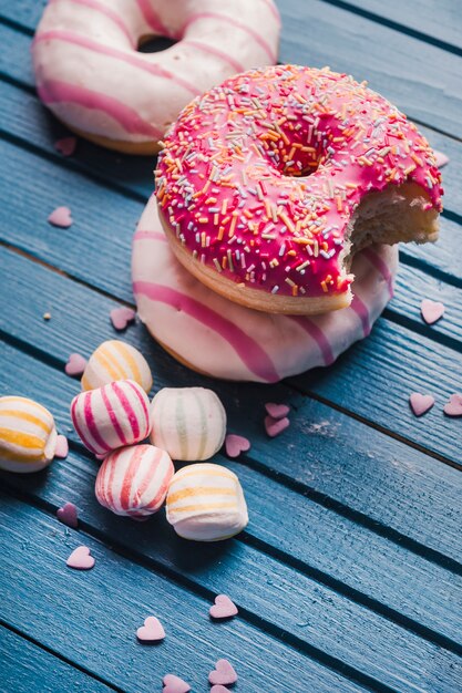 Foto gratuita tres sabrosas donas y dulces multicolores