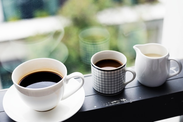 Tres tazas de café junto a la ventana