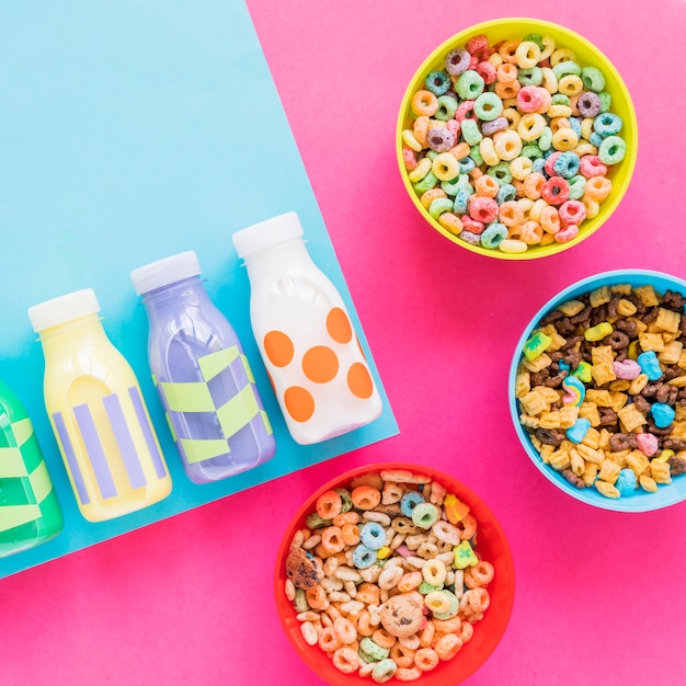 Tres tazones de cereales con botellas de leche.