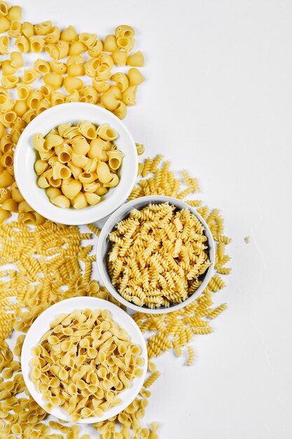 Tres tazones de pastas crudas en blanco