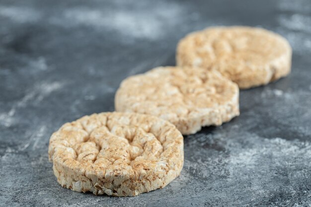 Tres tortas de arroz inflado sobre superficie de mármol