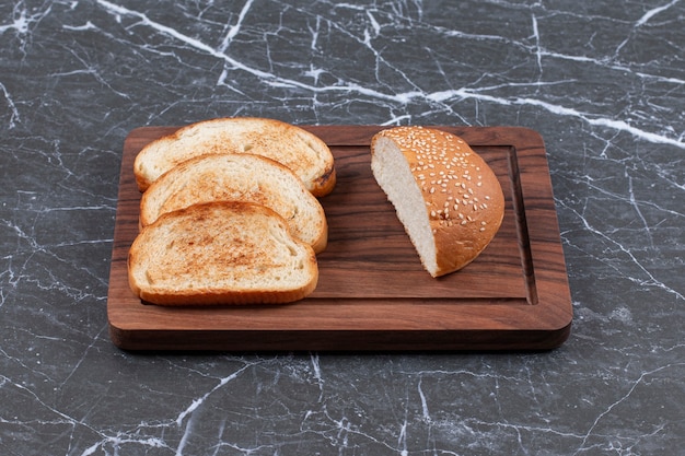 Foto gratuita tres tostadas dispuestas y bollo sobre la mesa.