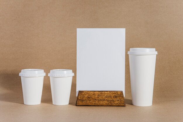 Tres vasos de café al lado de tabla blanca