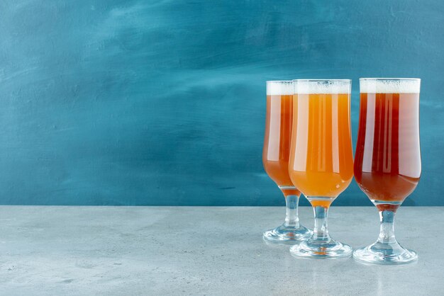 Tres vasos de cerveza ligera en azul