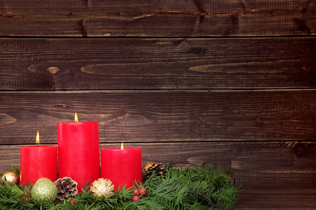 Foto gratuita tres velas rojas con decorados de navidad