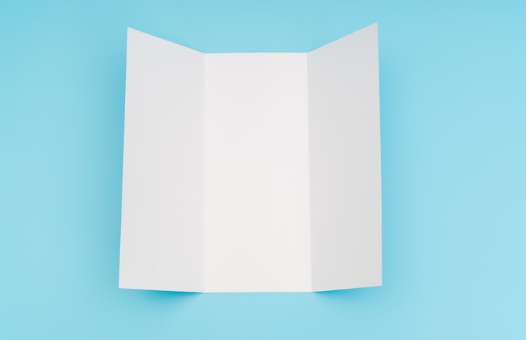 Foto gratuito trifold papel de plantilla blanco sobre fondo azul.