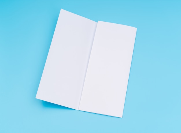 Trifold papel de plantilla blanco sobre fondo azul.