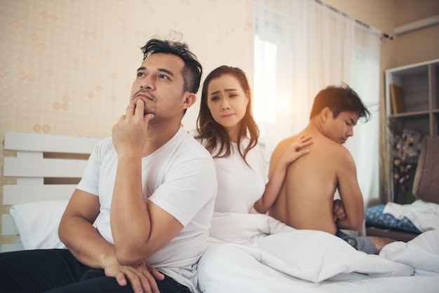 Triste cambio de mujer, chico, tiene muchos novios hablando en el dormitorio.