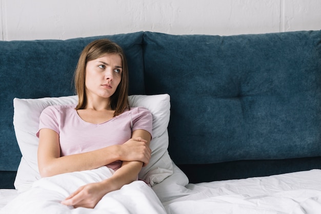 Triste contemplando mujer descansando en la cama