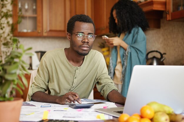 Triste hombre africano desempleado con gafas habiendo estresado mirada