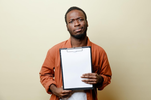 Triste joven afroamericano sosteniendo portapapeles aislado sobre fondo blanco.