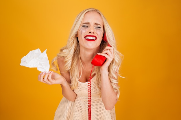 Triste llanto gritando joven rubia hablando por teléfono.