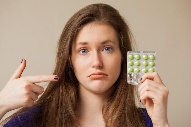 Triste mujer caucásica con pastillas