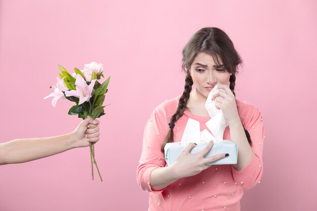 Triste mujer se le ofrecen flores mientras sostiene servilletas