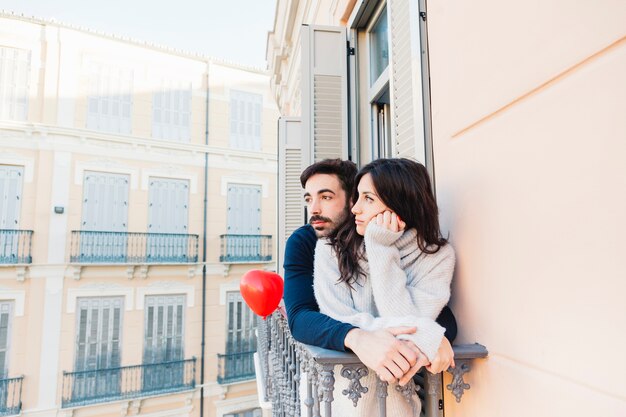 Triste pareja de pie en el balcón