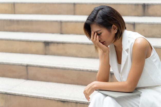 Tristeza joven llorando en la escalera