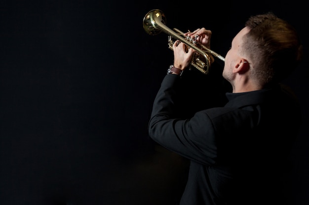 Foto gratuita trompetista sobre fondo negro