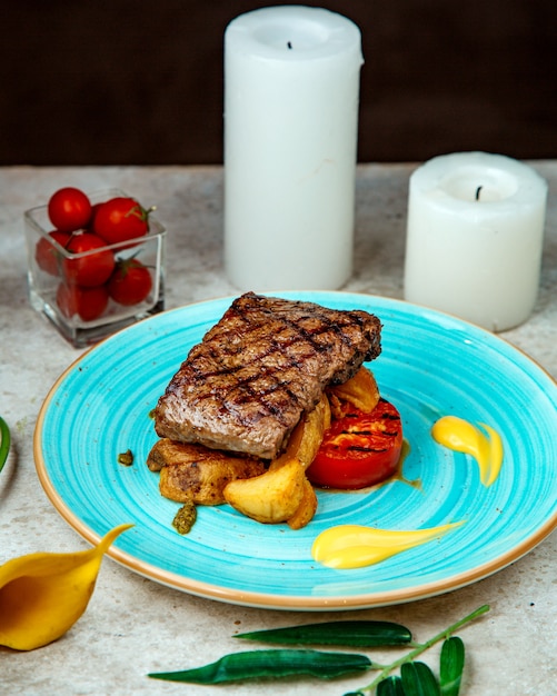 Foto gratuita trozo de carne frita papas y tomate frito