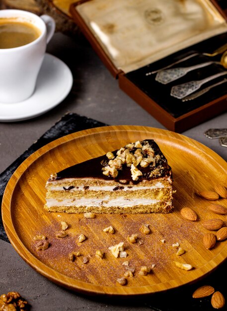 Un trozo de pastel con nueces de crema de vainilla y cubierto con glaseado de chocolate