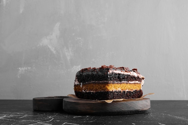 Un trozo de tarta de chocolate en un plato de madera.