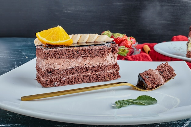 Un trozo de tarta con crema de chocolate y frutas.