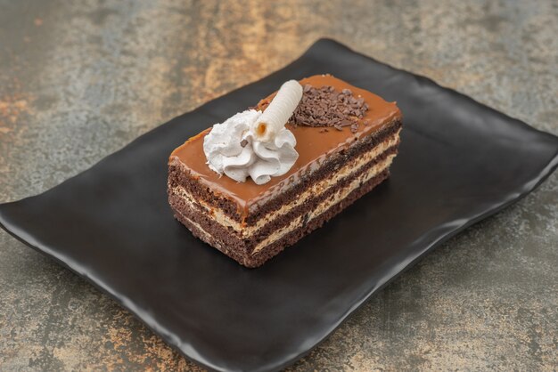 Un trozo de tarta dulce en un plato oscuro