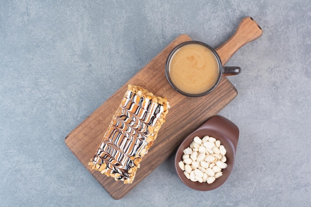 Un trozo de tarta con una taza de café aromático sobre superficie gris