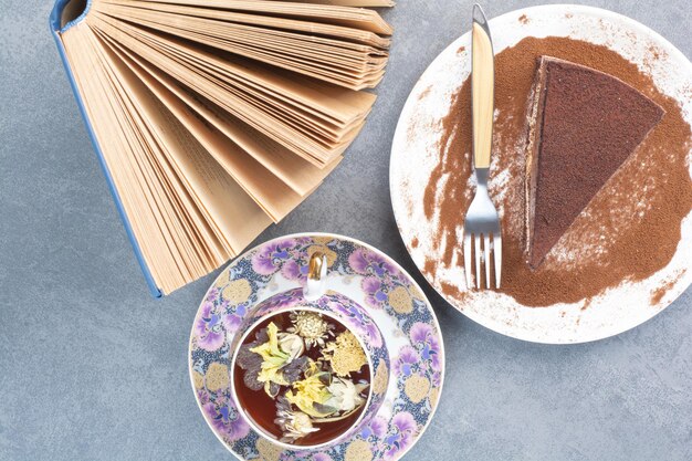 Un trozo de tarta con té aromático y libro.