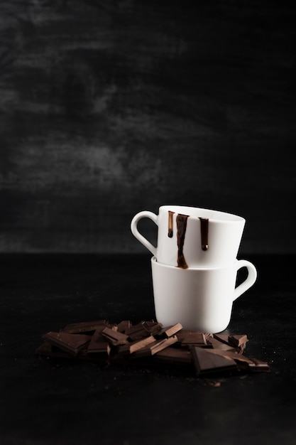 Trozos de chocolate y pila de tazas