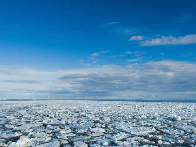 Trozos de hielo en el lago congelado bajo el cielo brillante en invierno