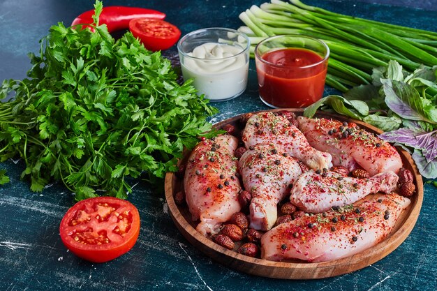 Trozos de pollo crudo con hierbas y especias.