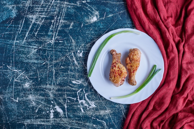 Trozos de pollo crudo con vegetación.