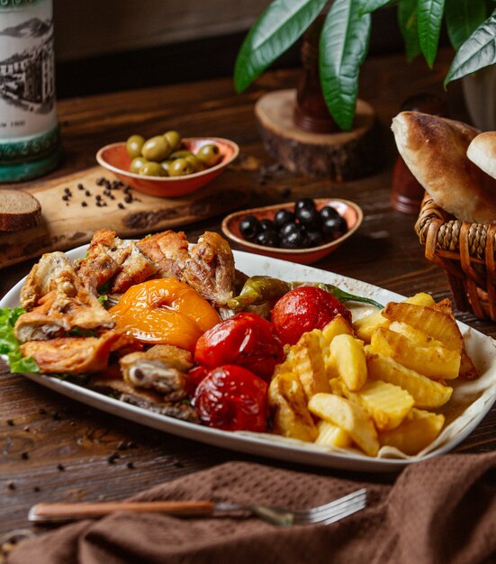 trozos de pollo frito con papas fritas, verduras a la parrilla