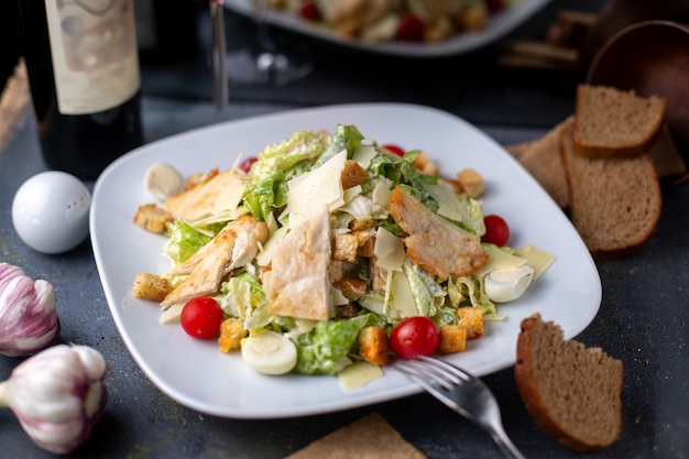 trozos de pollo en rodajas junto con verduras frescas vino tinto dentro de un plato blanco