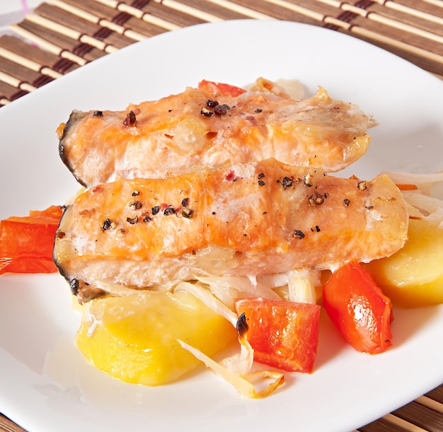 Trozos de salmón con papas, tomates y cebollas al horno