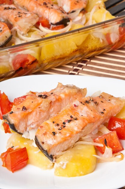 Trozos de salmón con papas, tomates y cebollas al horno