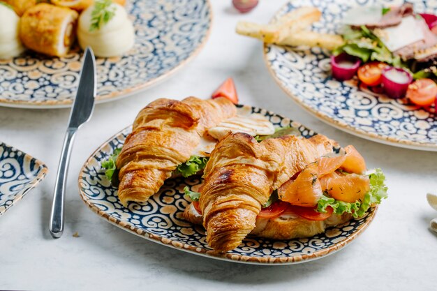 Trozos de salmón con rodajas de lechuga y tomate en croissant.