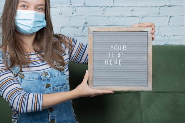 Tu cartel de texto aquí en la mano de una niña sobre la pandemia