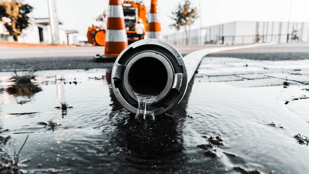 Tubo gris con agua saliendo de su agujero