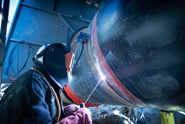 Foto gratuita tubo de soldadura soldador profesional en la construcción de una tubería