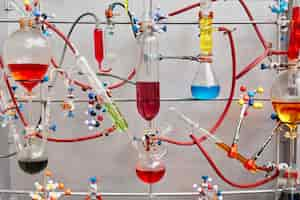 Foto gratuita tubos de ensayo de vidrio con líquido viscoso colorido aislado sobre superficie gris en laboratorio químico