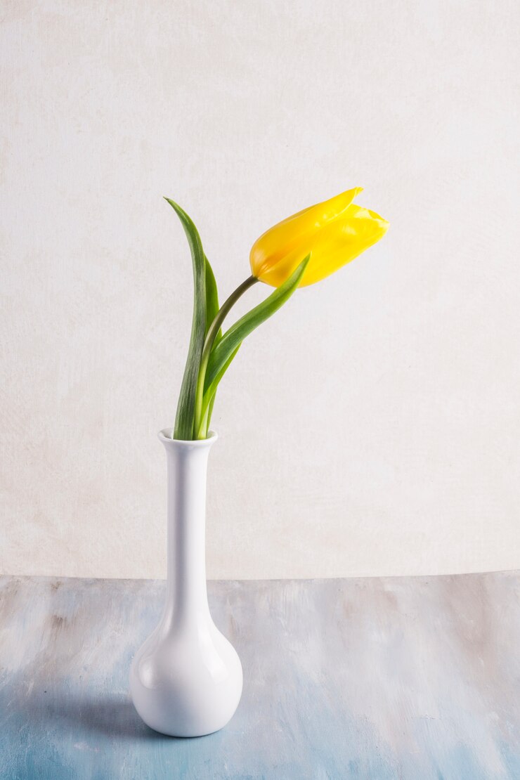Foto gratuito tulipán amarillo en jarrón sobre mesa