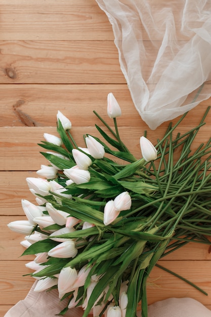 Tulipanes blancos sobre fondo de madera natural topview. Melodía de primavera