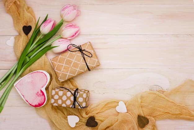 Tulipanes con cajas de regalo y corazones.