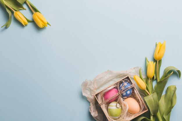 Tulipanes cerca de la caja con huevos