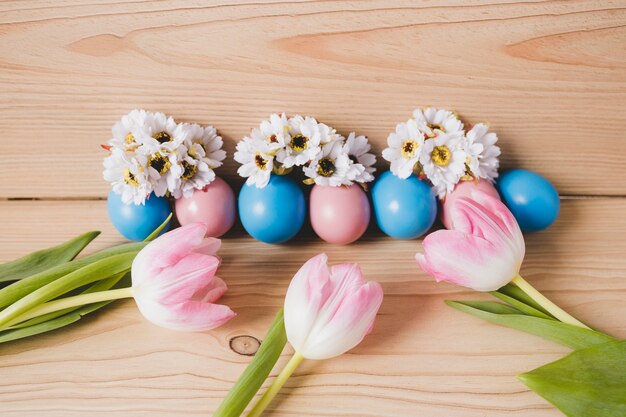 Tulipanes cerca de huevos de Pascua y flores