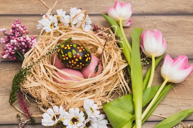 Tulipanes cerca del nido con huevos de Pascua