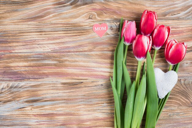 Tulipanes decorativos sobre superficie de madera para el día de la madre