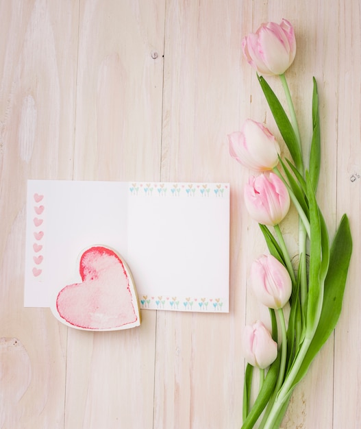 Tulipanes con papel en blanco y corazón