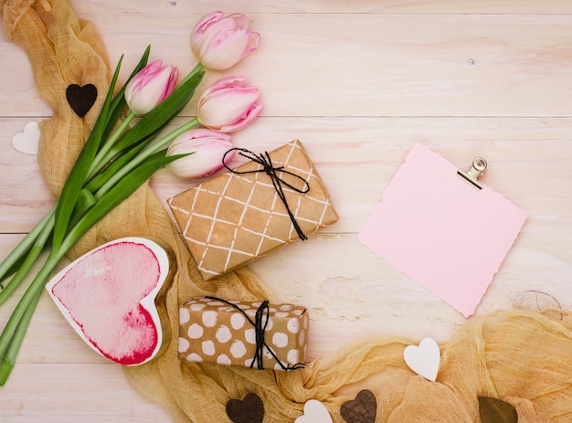 Tulipanes con pequeñas cajas de regalo y papel.